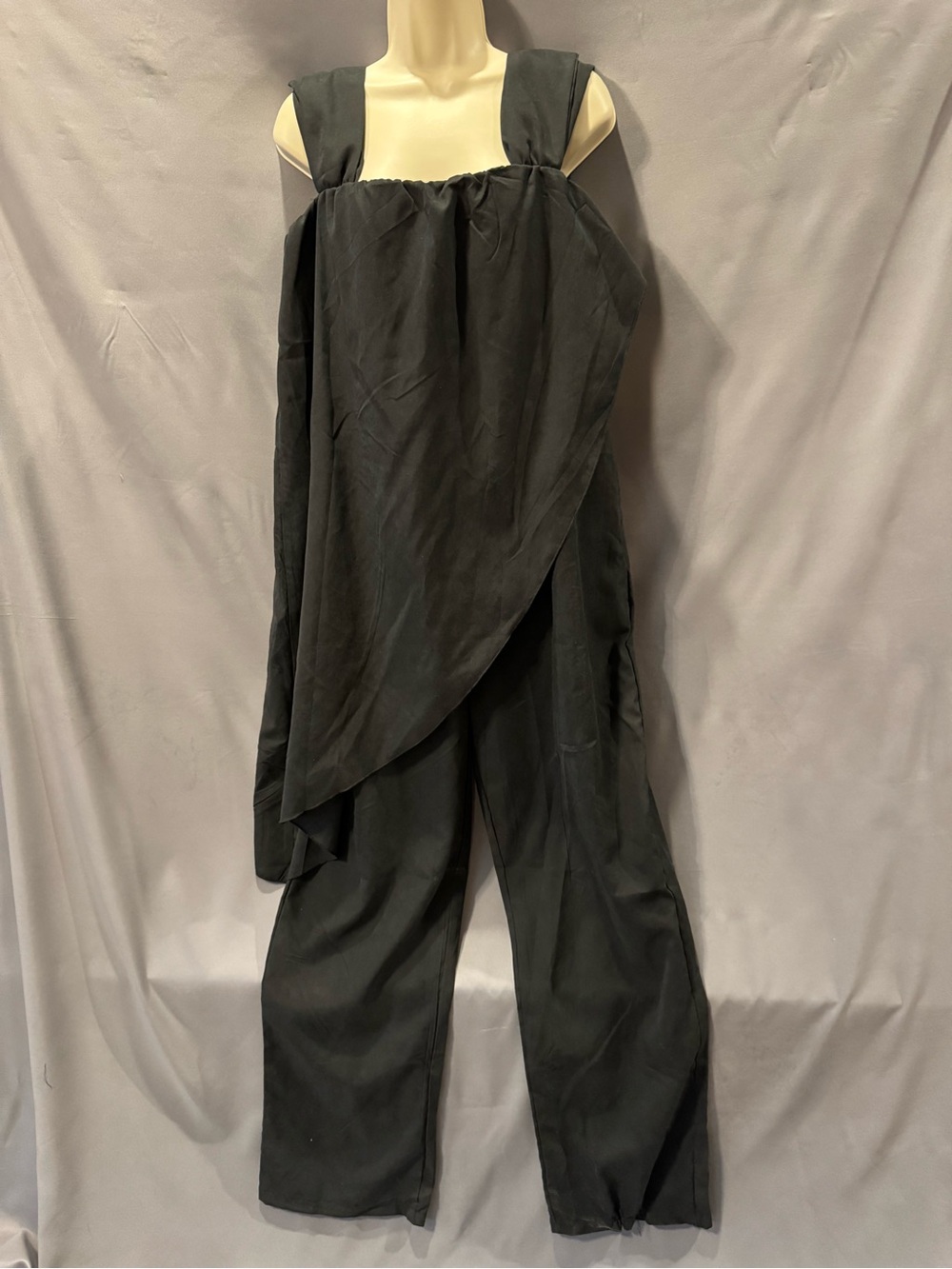 black draped or asymmetrical jumpsuit wide-leg trousers and a layered flowy
